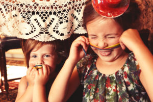 Party Girls eating sweet and sour candy spaghetti under the table Party Girls eating sweet and sour candy spaghetti under the table